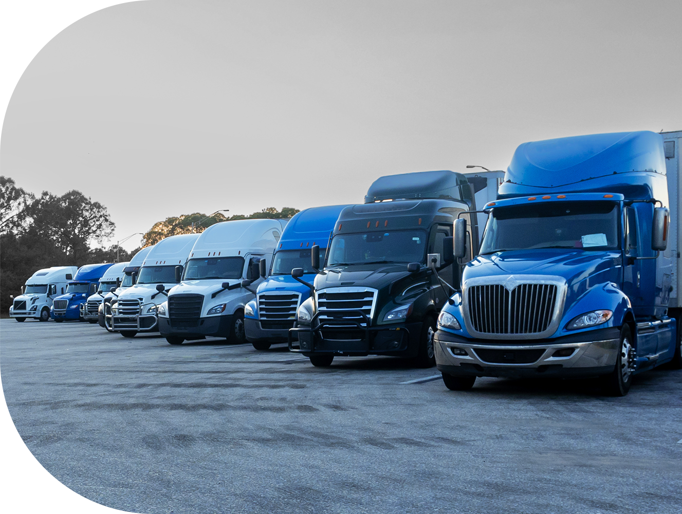 Stryder Logistics North American partner fleet with blue and white tractors and trailers including parked dry vans, reefers, flatbeds, roll-tites, chassis and more